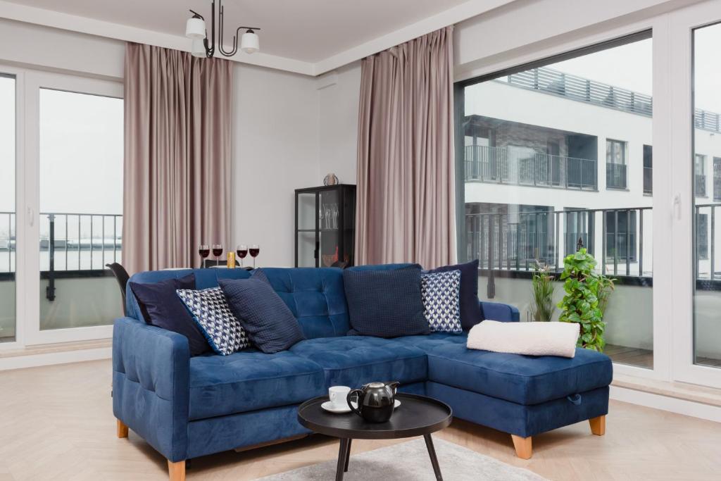 a living room with a blue couch and a table at Mokotów Apartment LUX with Parking by Renters Prestige in Warsaw