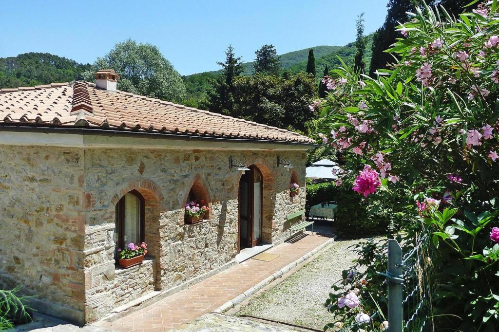 un edificio de piedra con flores en un jardín en Holiday home Casa Carla, Ripafratta, en Ripafratta