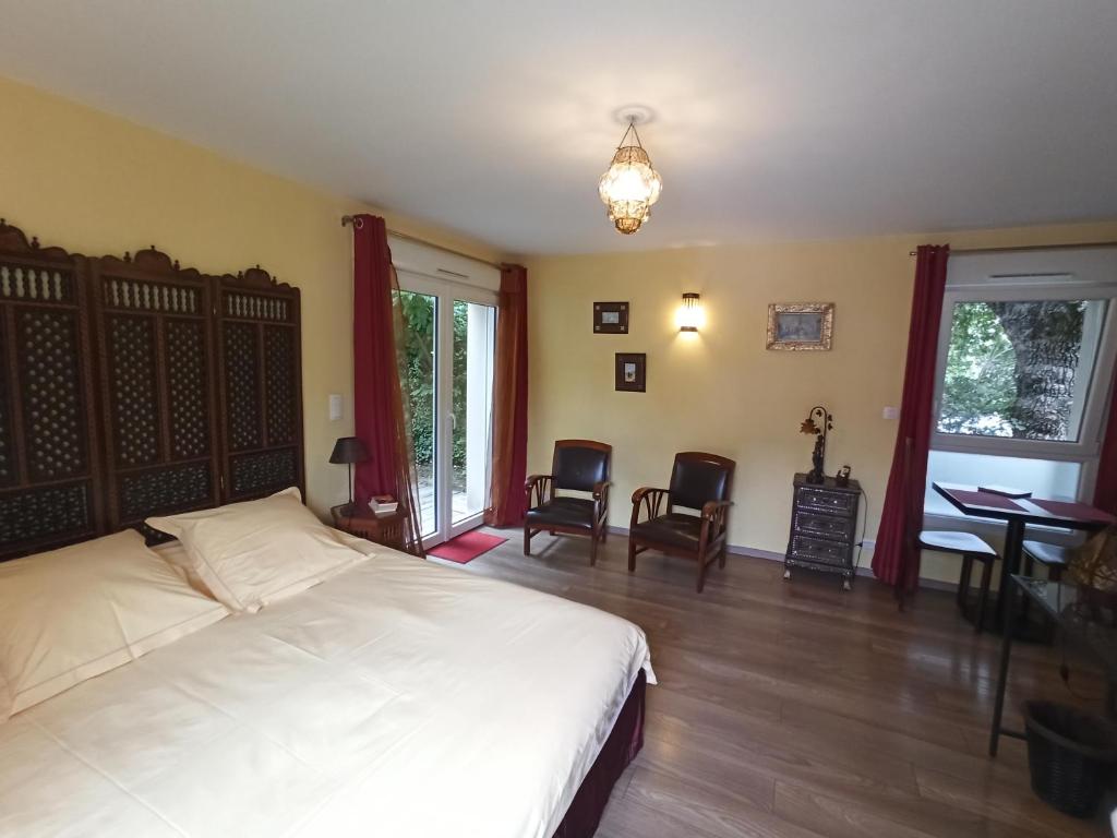 - une chambre avec un lit, une table et des chaises dans l'établissement Au Cadran Solaire, à Nantes