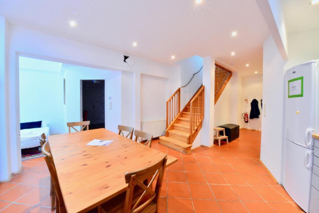 a kitchen and dining room with a wooden table and chairs at Spacious Flat with Panoramic View in Vienna