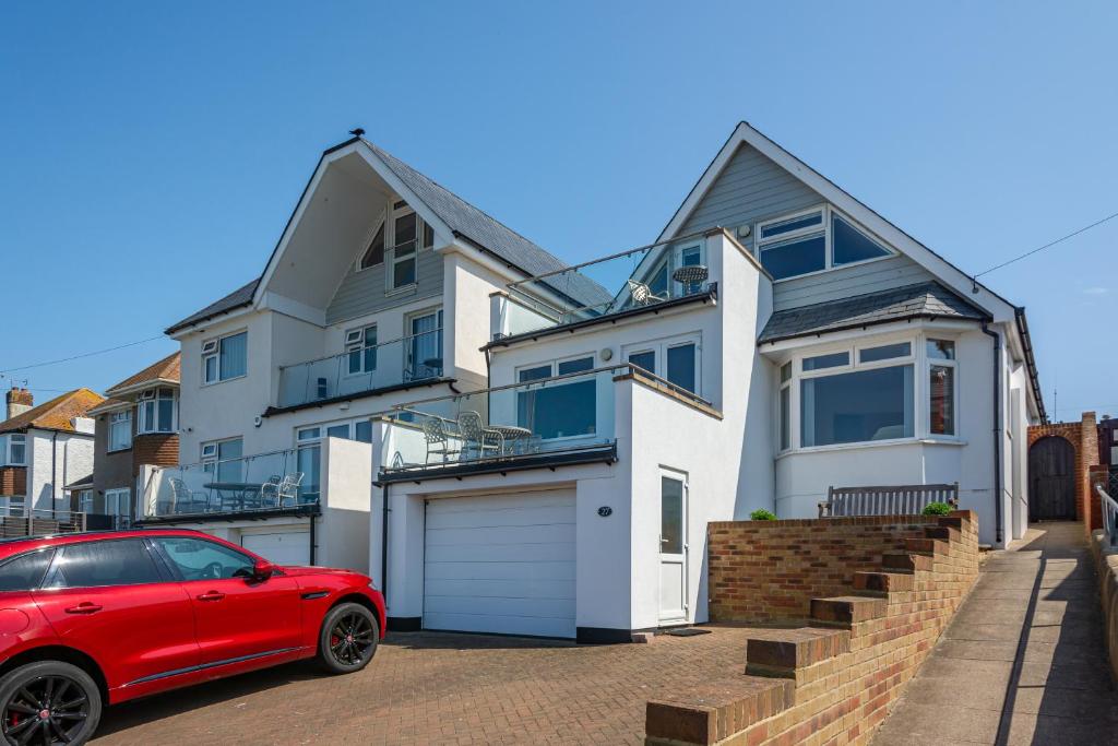 a red car parked in front of a house at A Spacious Seaside house in Hampton, Herne Bay in Herne Bay