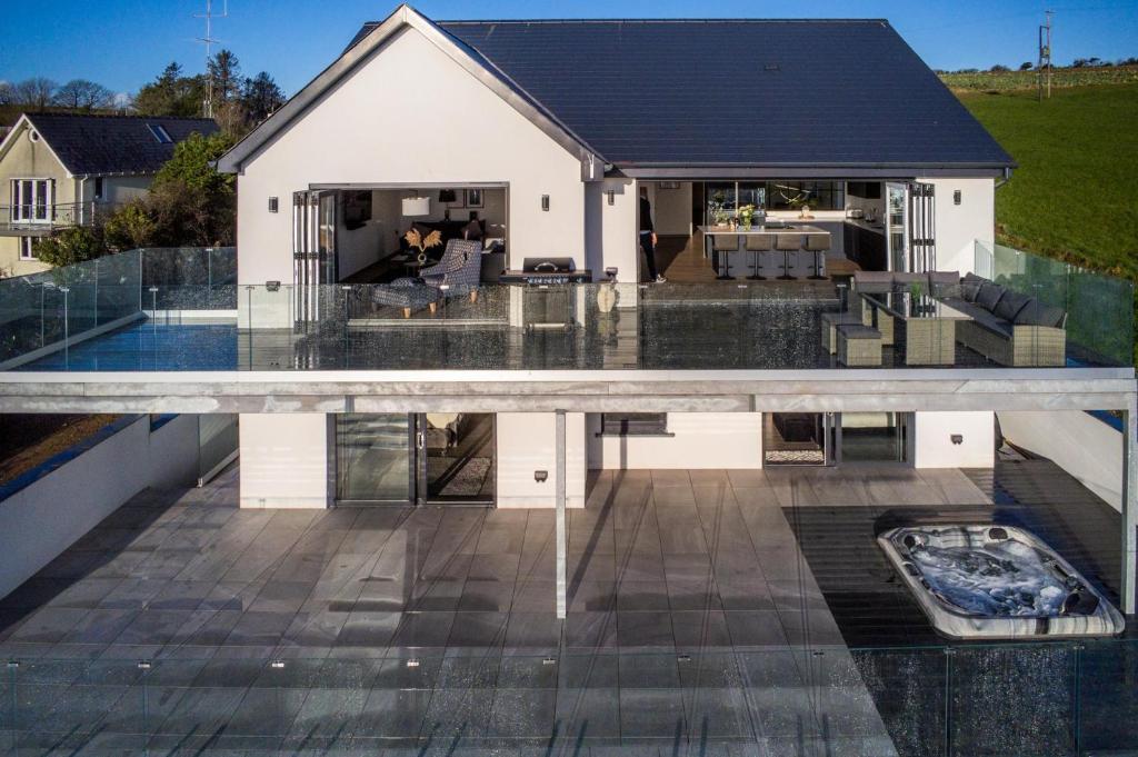 einem externen Blick auf ein Haus mit einem Pool in der Unterkunft Sunrise - 5 Bedroom Luxurious Holiday Home - Pendine in Pendine