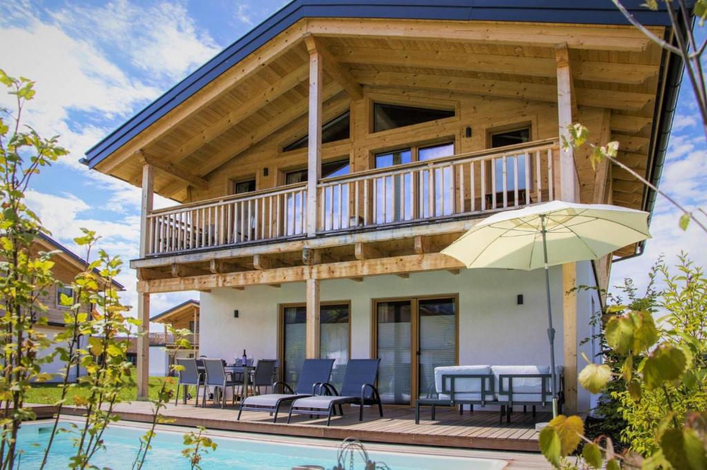 ein Haus mit einem Balkon und einem Pool in der Unterkunft Bergchalet Falkenstein, Inzell in Inzell