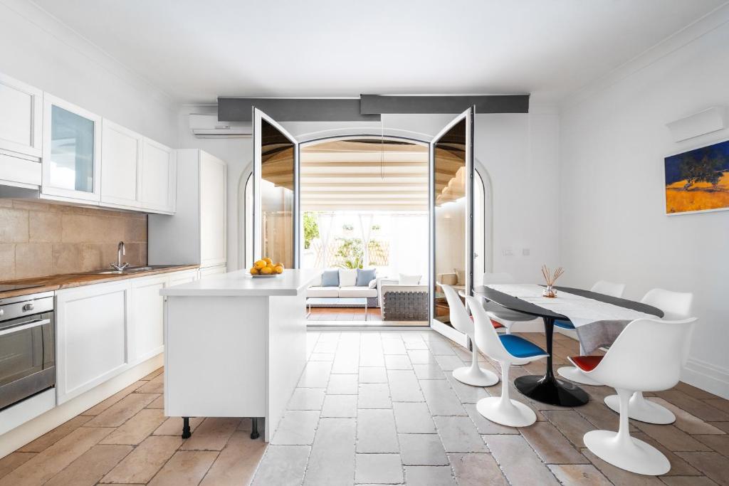 a kitchen with white cabinets and a table and chairs at Casa Malu in Positano