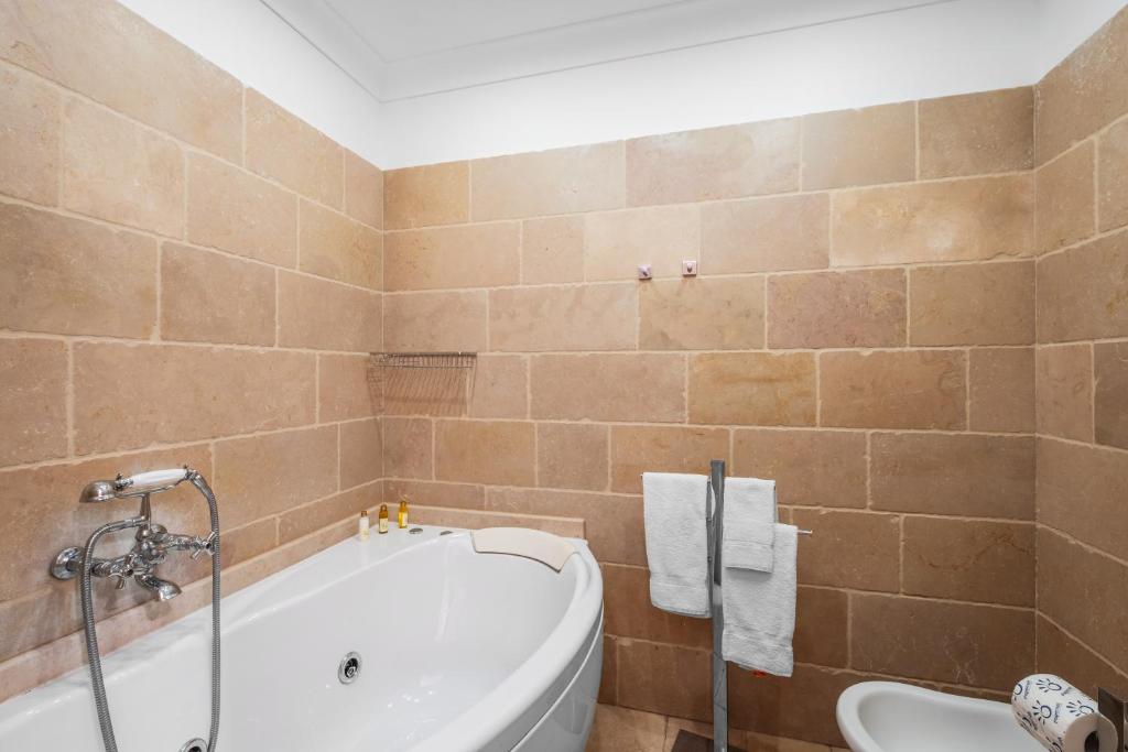 a bathroom with a bath tub and a toilet at Casa Malu in Positano