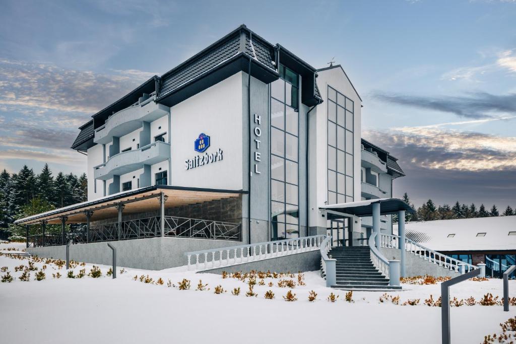 ein Hotel im Schnee vor einem Gebäude in der Unterkunft Saltzbork in Staraya Solʼ