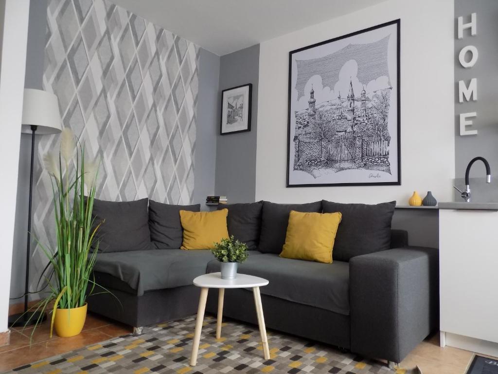a living room with a gray couch and a table at Fészek Apartman Sopron in Sopron