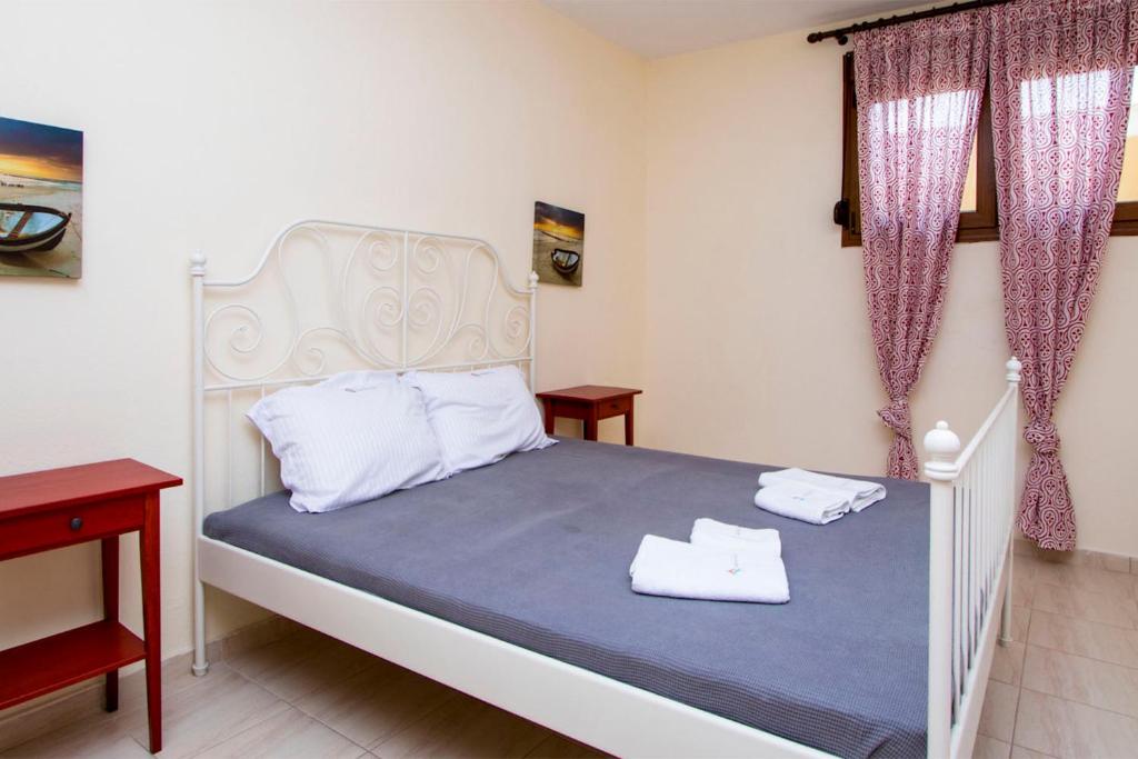 a bedroom with a bed with two white towels on it at Possidi Villas by Halkidiki Villas in Possidi