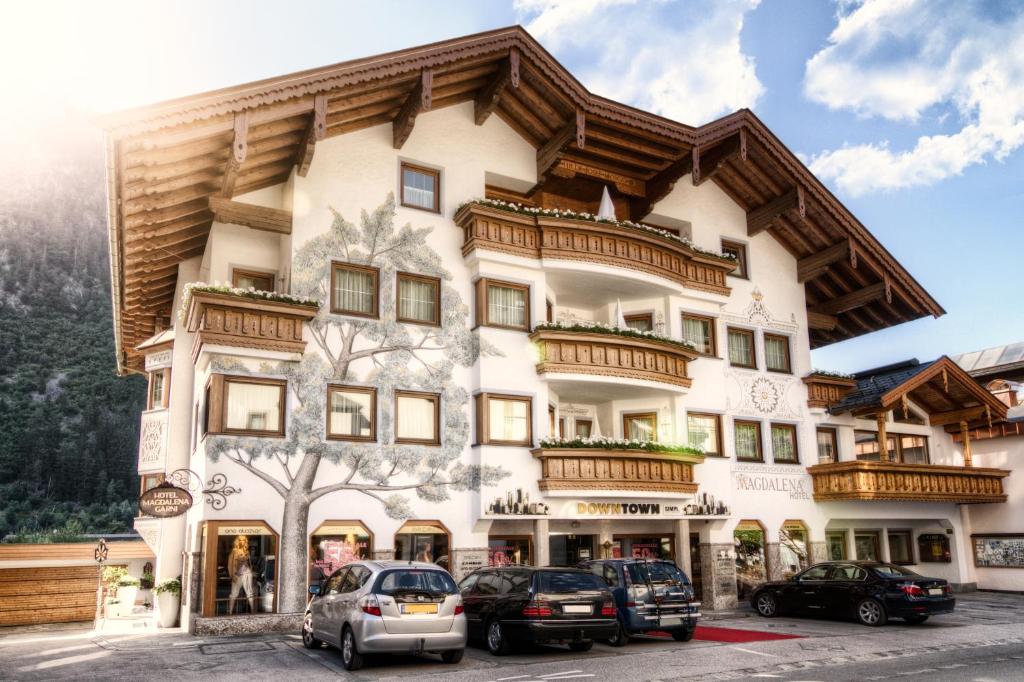 un gran edificio con coches estacionados frente a él en Hotel Magdalena Mayrhofen, en Mayrhofen