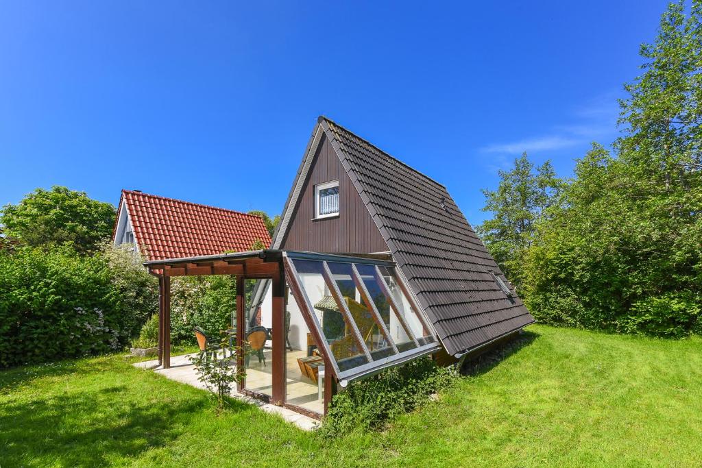 ein kleines Haus mit einem Pavillon im Hof in der Unterkunft Ferienhaus Windspiel in Neuharlingersiel