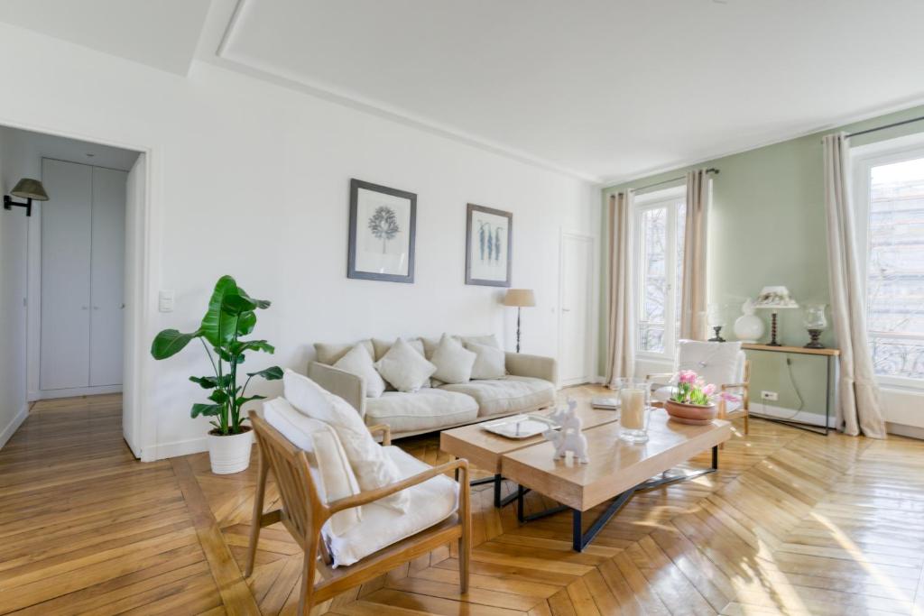 sala de estar con sofá y mesa en Superbe appart de 129m2, 3 ch-Neuilly 2 min Paris en Neuilly-sur-Seine