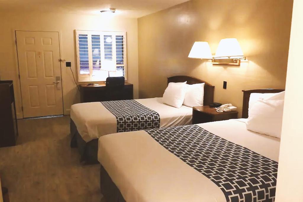 a hotel room with two beds and a window at Coratel Inn & Suites by Jasper McCook in McCook