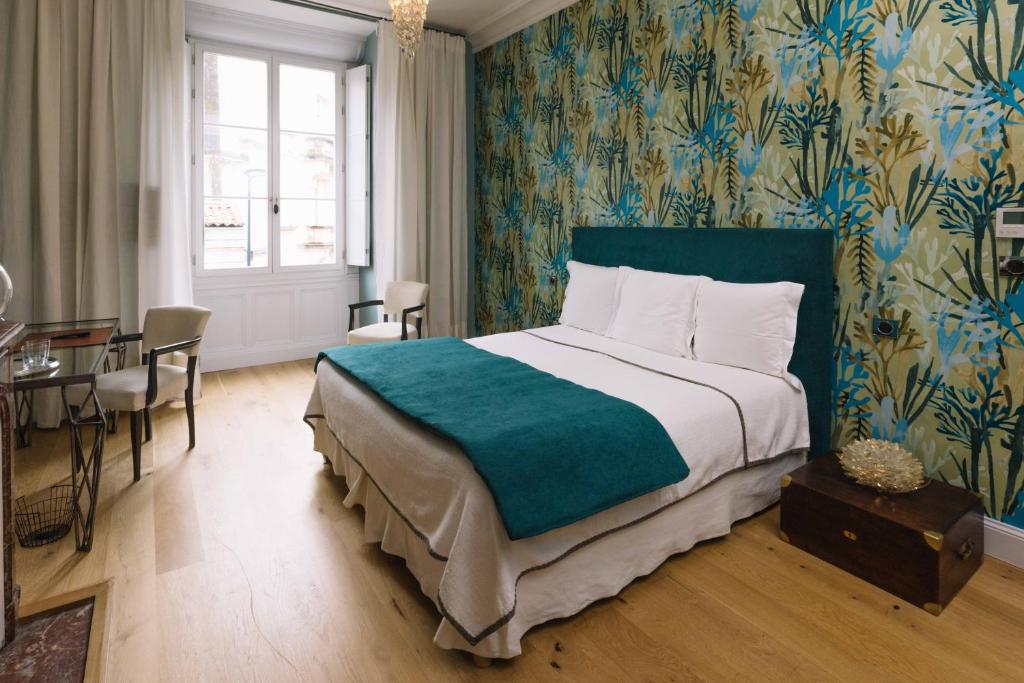 sypialnia z dużym łóżkiem, stołem i krzesłami w obiekcie La Course w mieście Bordeaux