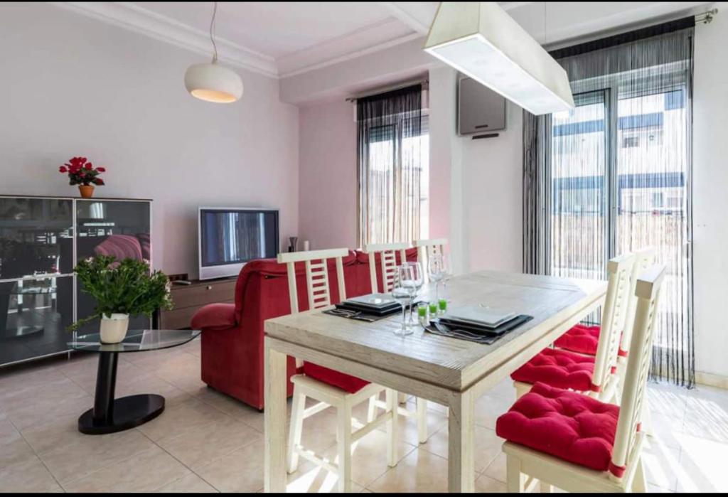 a living room with a dining room table with red chairs at PRECIOSO APARTAMENTO EN EL BARRIO DE RUZAFA in Valencia