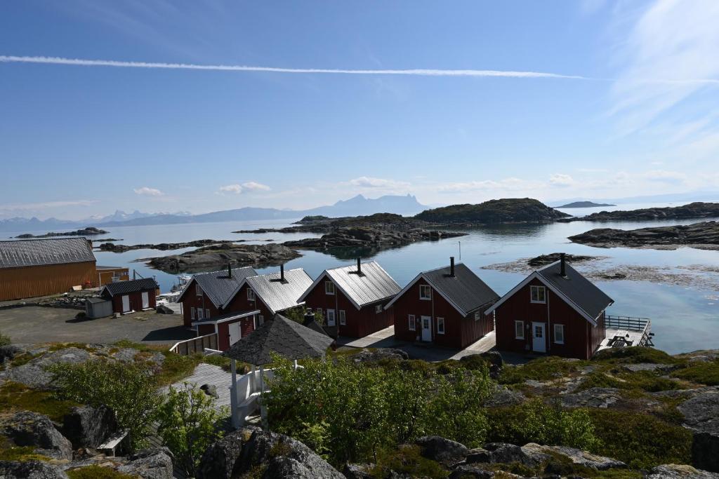 eine Reihe von Häusern am Ufer eines Wasserkörpers in der Unterkunft Offersøy Feriesenter in Offersøy