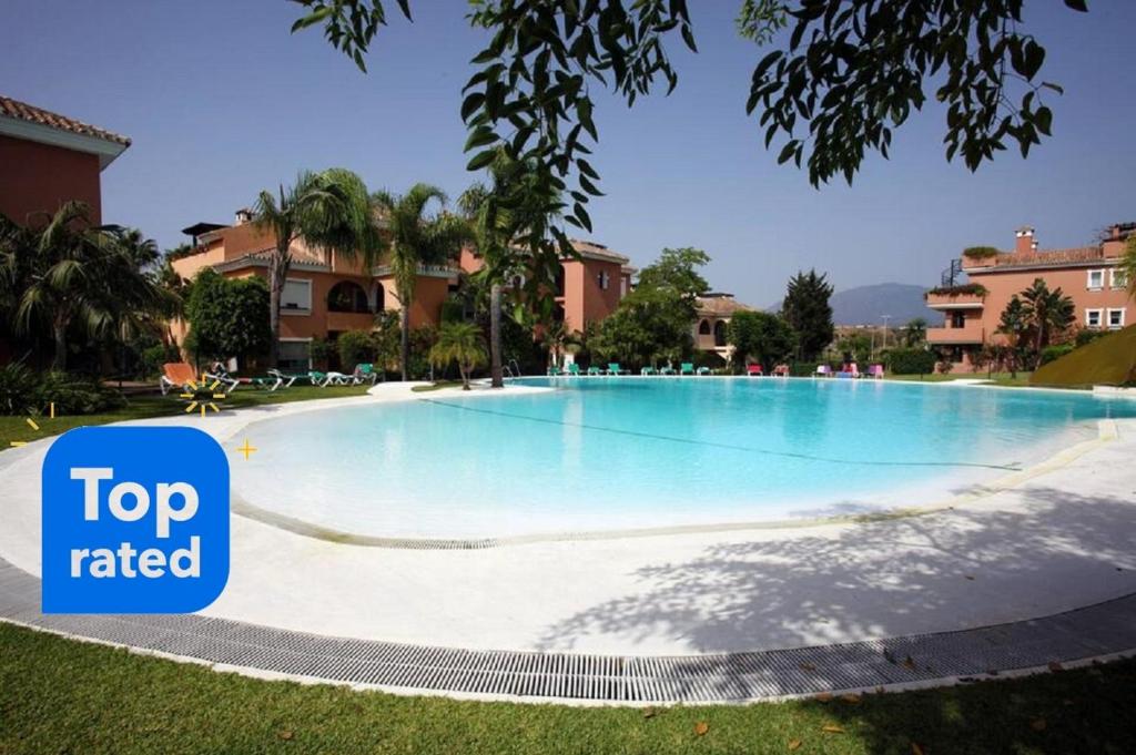 una grande piscina con un cartello che dice "top-value" di Apartamento entre Marbella y Estepona a Estepona
