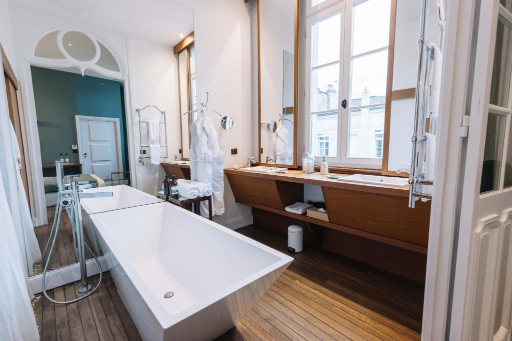 a bathroom with a large sink and a large mirror at La Course in Bordeaux