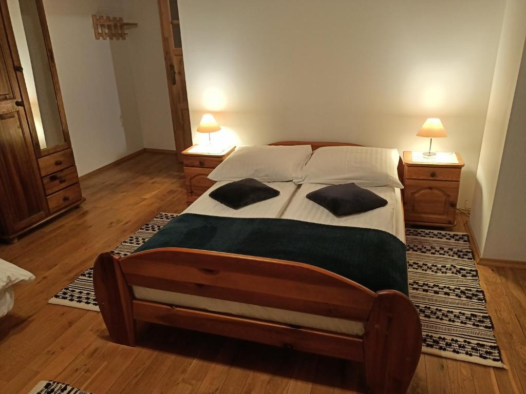 a bedroom with a large bed with two night stands at Mala Chatka in Wetlina