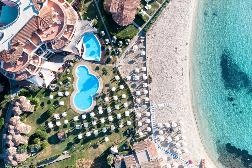 an aerial view of a resort with a pool and a beach at Baia Caddinas Clubresidence in Golfo Aranci