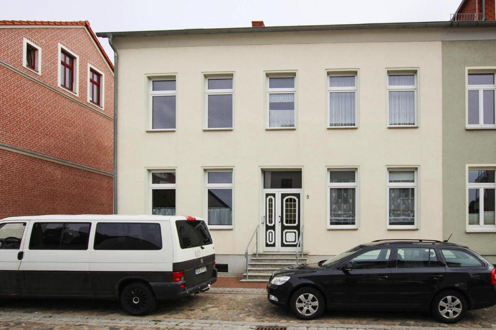 a white van and a black car parked in front of a building at Apartment in Malchow with terrace in Malchow