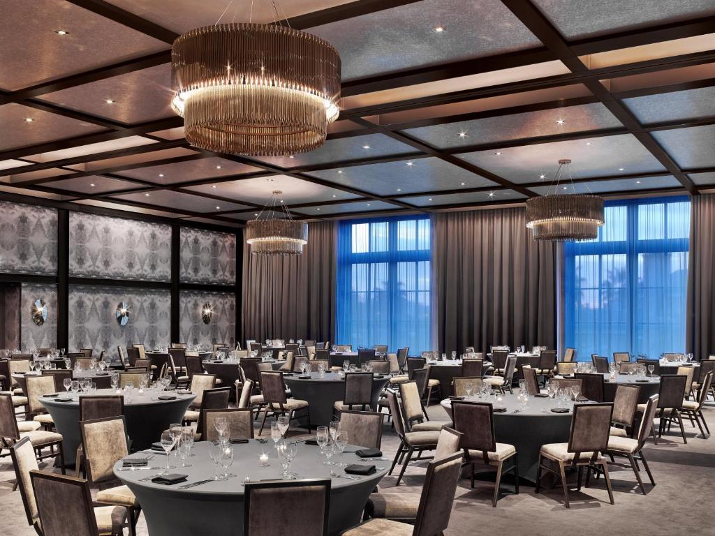 a banquet hall with tables and chairs and chandeliers at Hotel Van Zandt in Austin