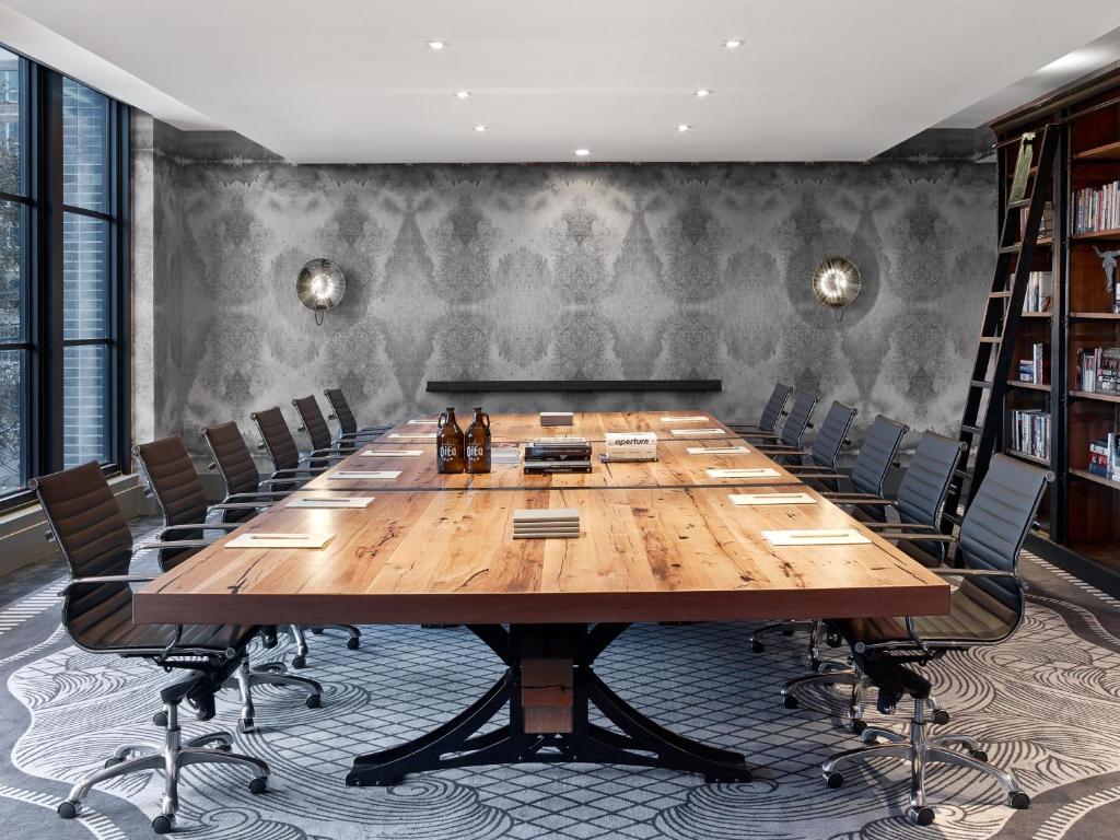 a conference room with a large wooden table and chairs at Hotel Van Zandt in Austin