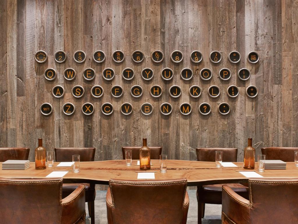 a table with chairs and a wall with wine bottles at Hotel Van Zandt in Austin