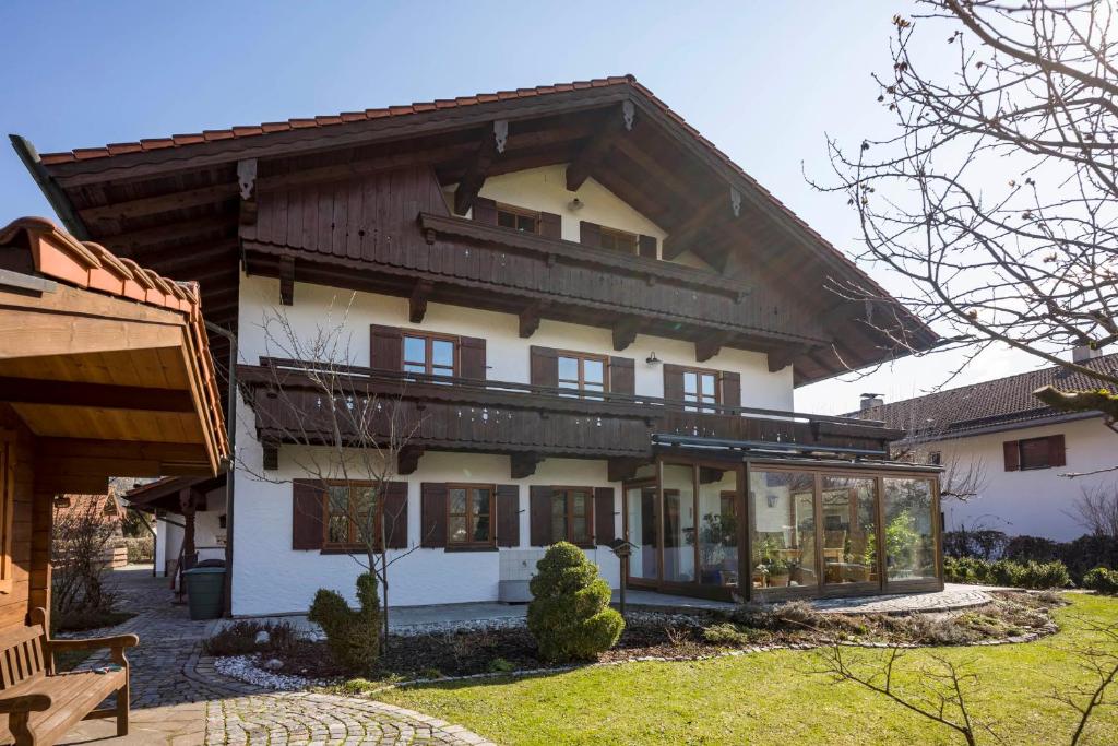 uma grande casa branca com um telhado de madeira em Ferienwohnung Gerstner em Oberaudorf