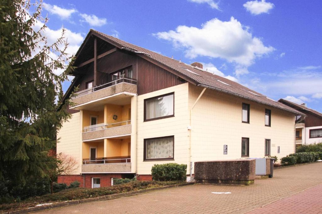 ein großes weißes Gebäude mit Balkon auf einer Straße in der Unterkunft Apartment Braunlage in Braunlage