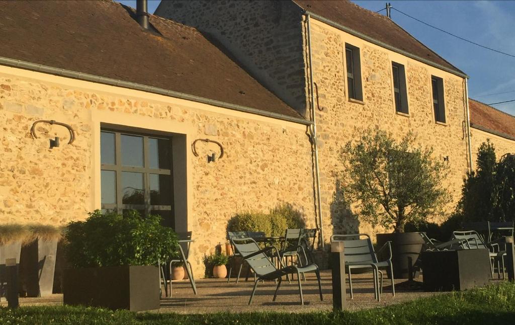 un grupo de sillas sentadas fuera de un edificio en La Grange Saint Martin, en Fontaine-le-Port