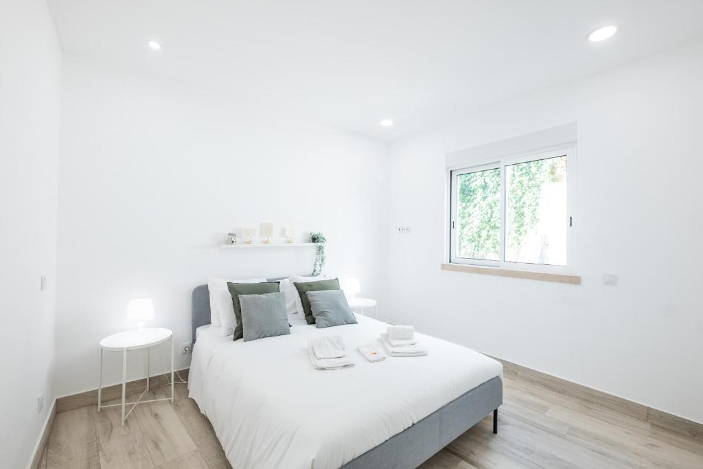 a white bedroom with a white bed and a window at #074 Casa dos Arcos by Home Holidays in Albufeira