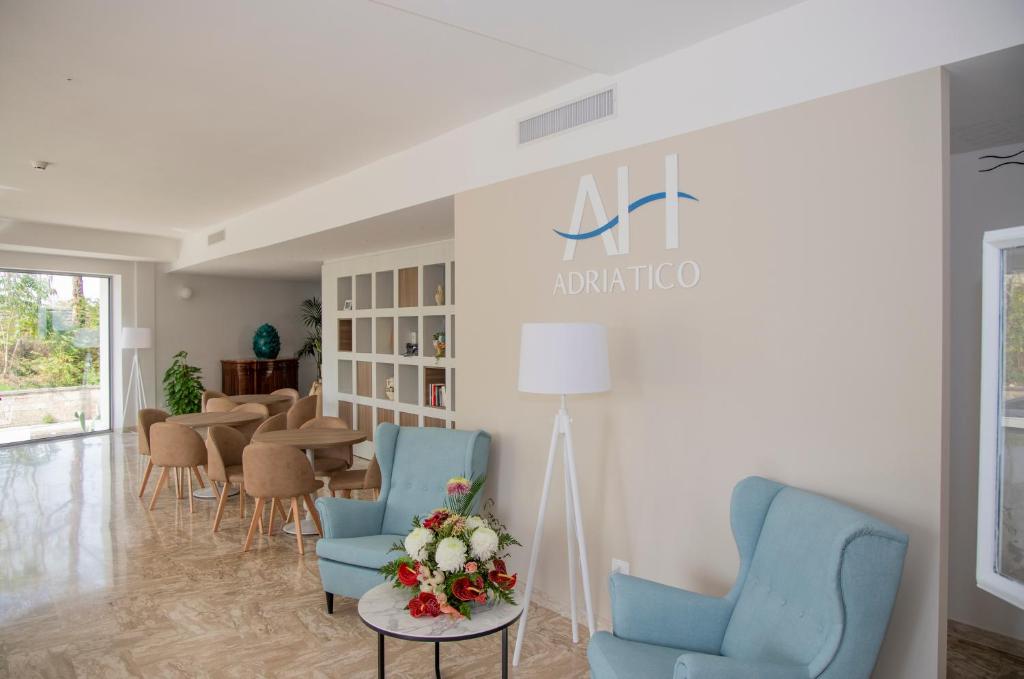 - une salle d'attente avec des chaises bleues et une table dans l'établissement Hotel Adriatico, à Tricase
