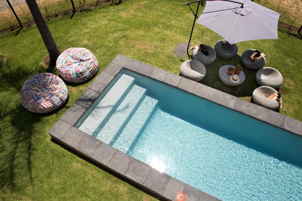 an overhead view of a swimming pool with an umbrella at Sunshowers Plett in Plettenberg Bay