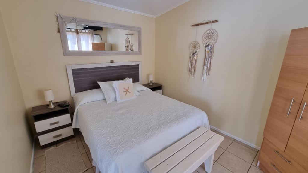 a bedroom with a bed and a bench in it at Cabañas Pinamar in La Serena