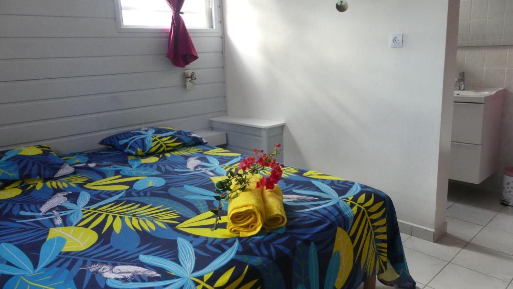 a bedroom with a bed with a yellow purse on it at Ti Colibri in Port-Louis