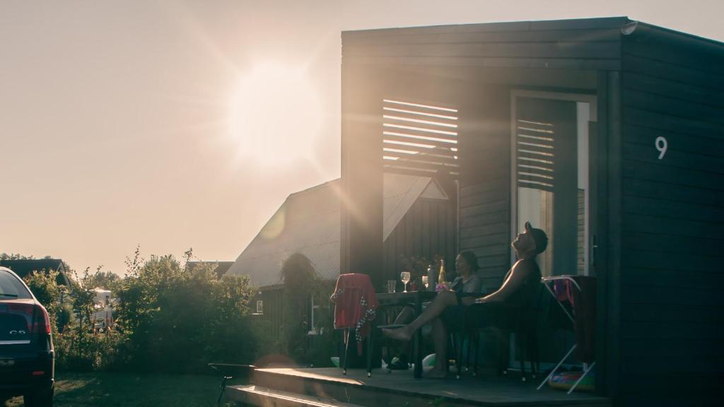 zwei Frauen an einem Tisch vor einem Haus in der Unterkunft Asaa Camping & Cottages in Aså