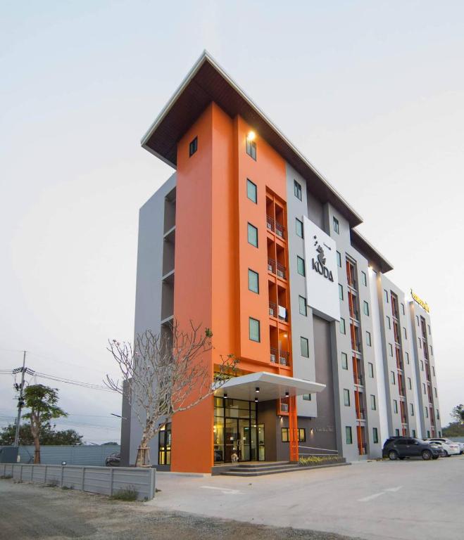a large building with an orange and gray at Kuda Asia Hotel Bang Saen in Bangsaen