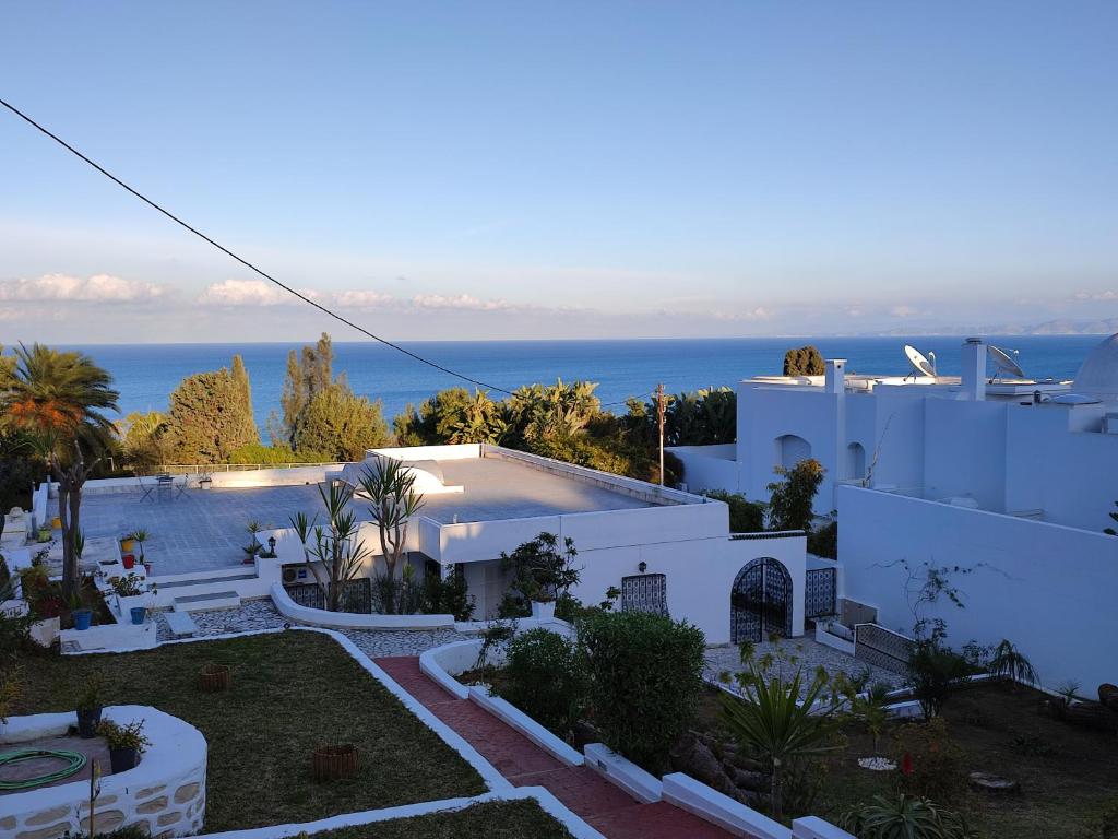 una casa blanca con el océano en el fondo en Villa Ambre, en Gammarth