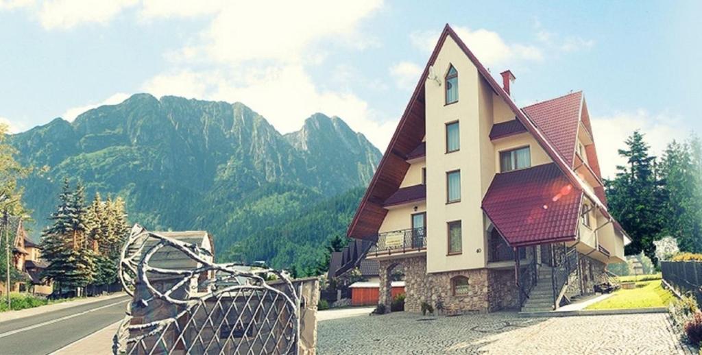 a house with a fence in front of a mountain at Willa Hawrań in Zakopane