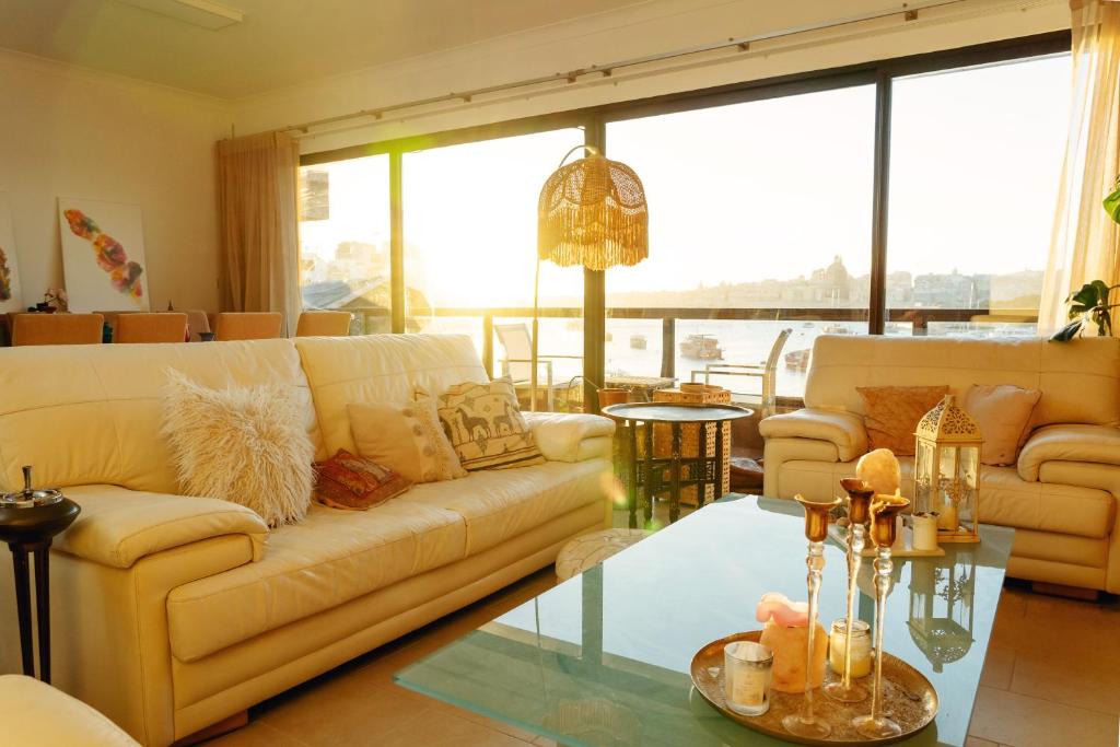 a living room with a couch and a glass table at Private rooms in seafront apartment in Sliema