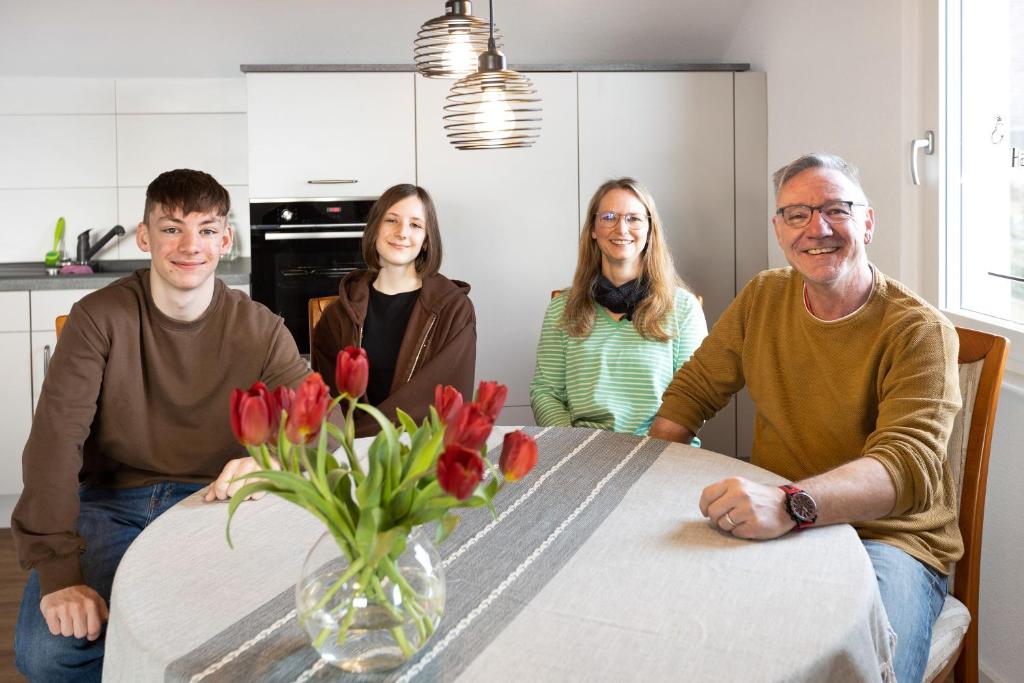 Un groupe de personnes assises autour d'une table avec un vase de fleurs dans l'établissement kleine Auszeit, à Albbruck