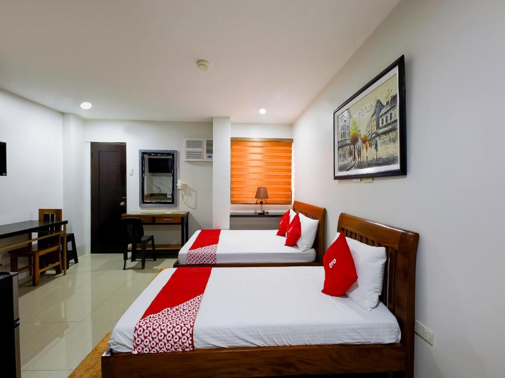 1 dormitorio con 2 camas y escritorio con piano en OYO 848 Dona Aurora Condotel en Manila