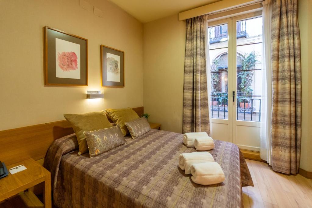 1 dormitorio con 1 cama con 2 almohadas en El Pasaje, en Madrid