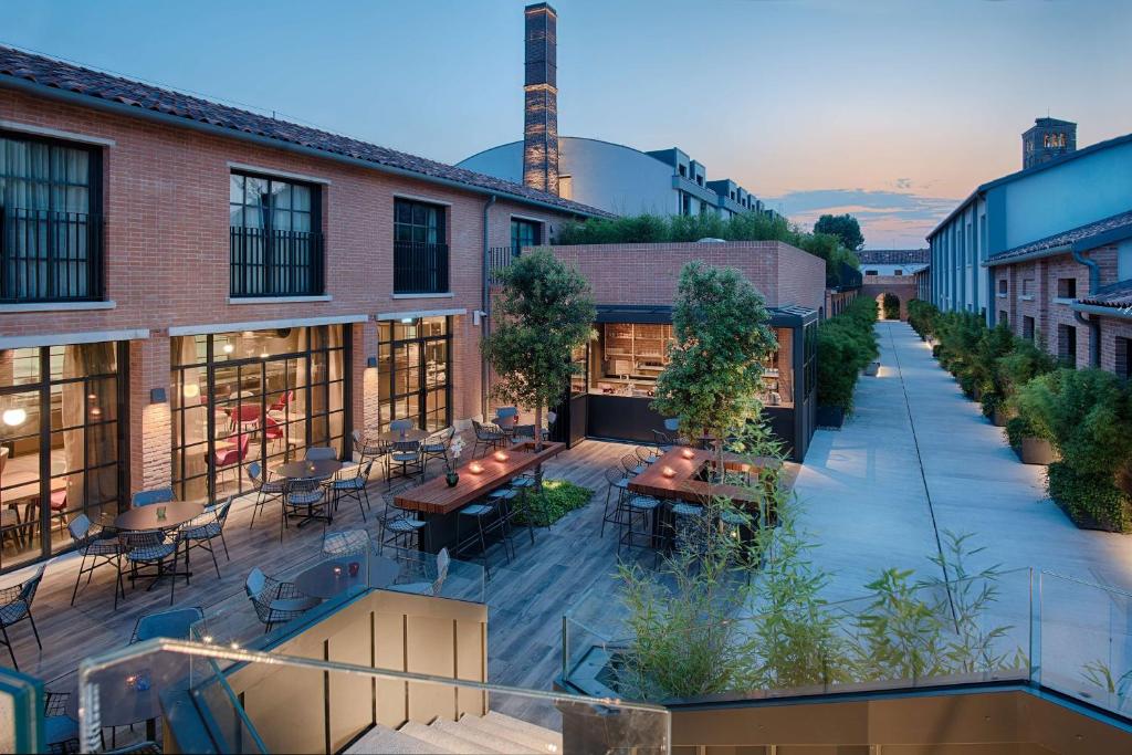 an outdoor patio with tables and chairs on a building at NH Collection Murano Villa in Murano