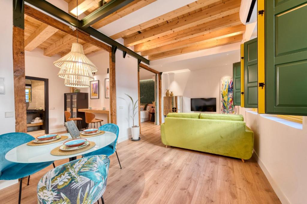uma sala de estar com um sofá verde e uma mesa e cadeiras em Boutique D’Argent em Toledo