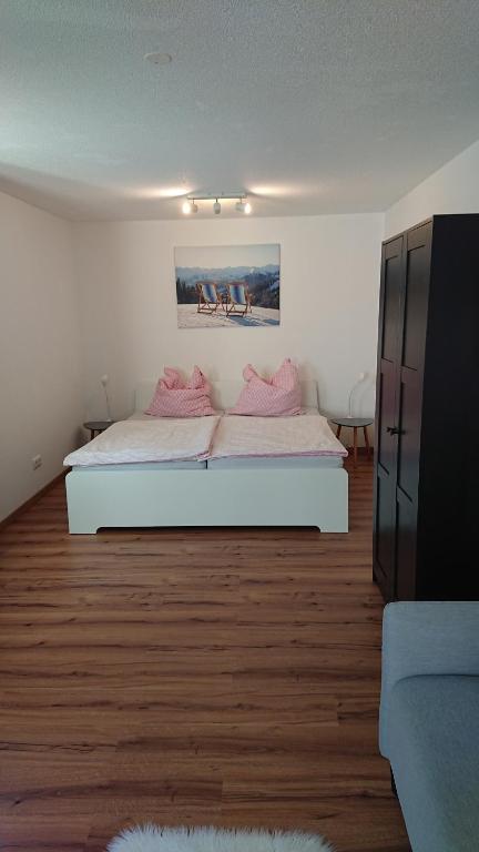 um quarto com uma cama com almofadas cor-de-rosa em Ferienwohnung Astis em Blaichach