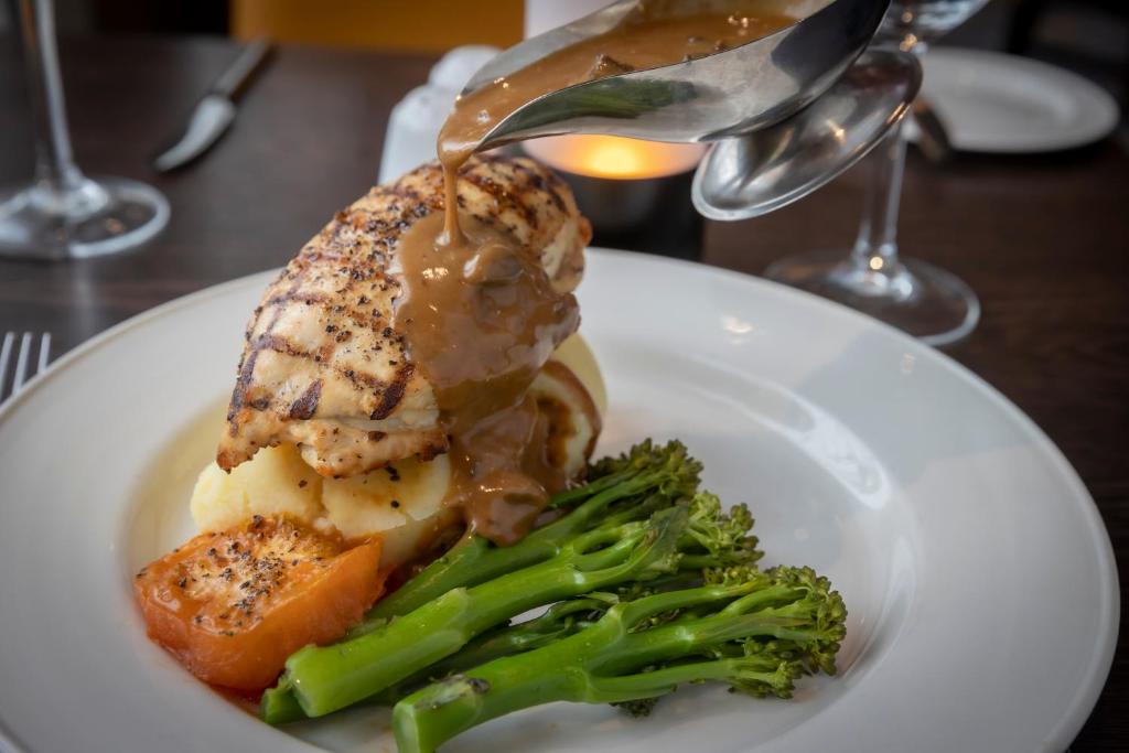 a plate of food with meat and vegetables on a table at Maldron Hotel Belfast International Airport in Aldergrove