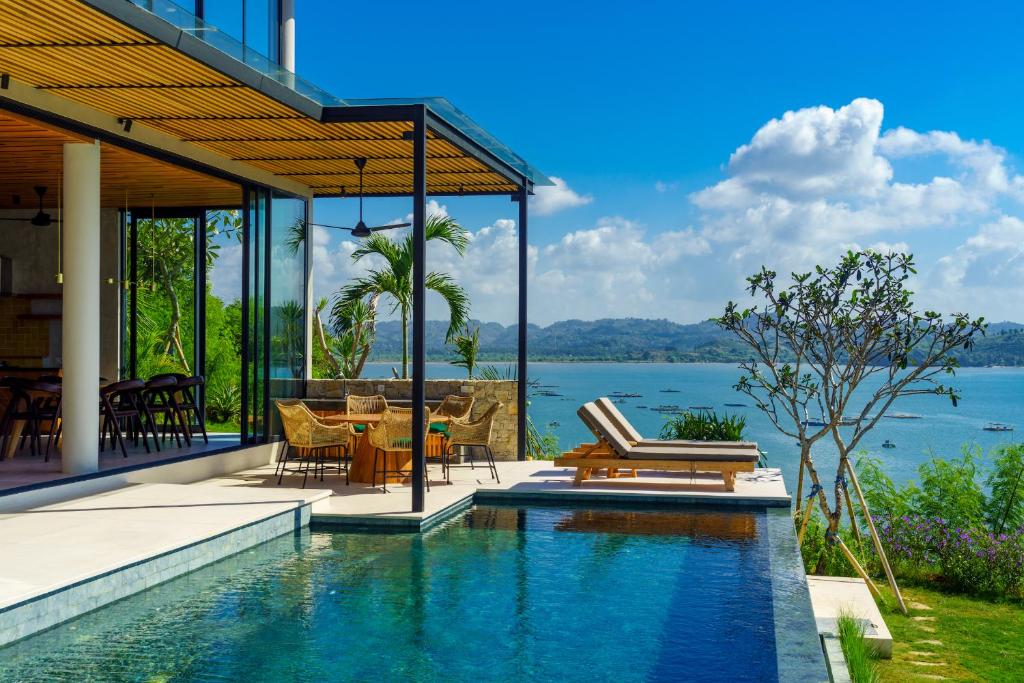 a house with a swimming pool with a view of the water at Villa Utamaro in Bumbang