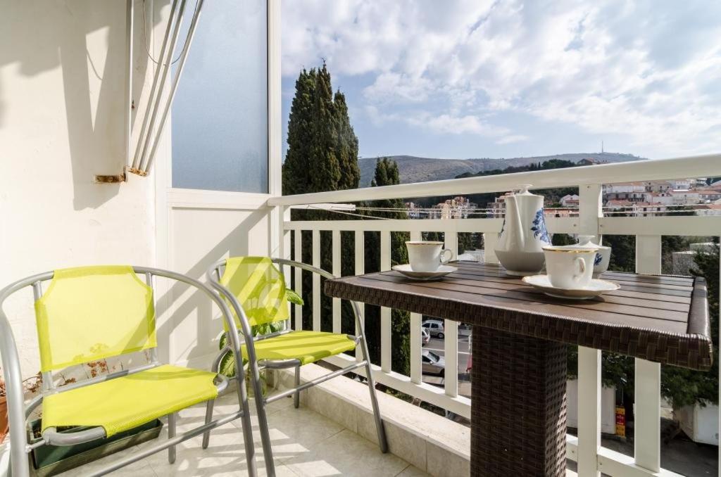 Una mesa y sillas en un balcón con vista. en Apartment Nina, en Dubrovnik