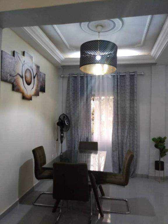 a dining room with a table and chairs and a ceiling at Your home II in Yaoundé